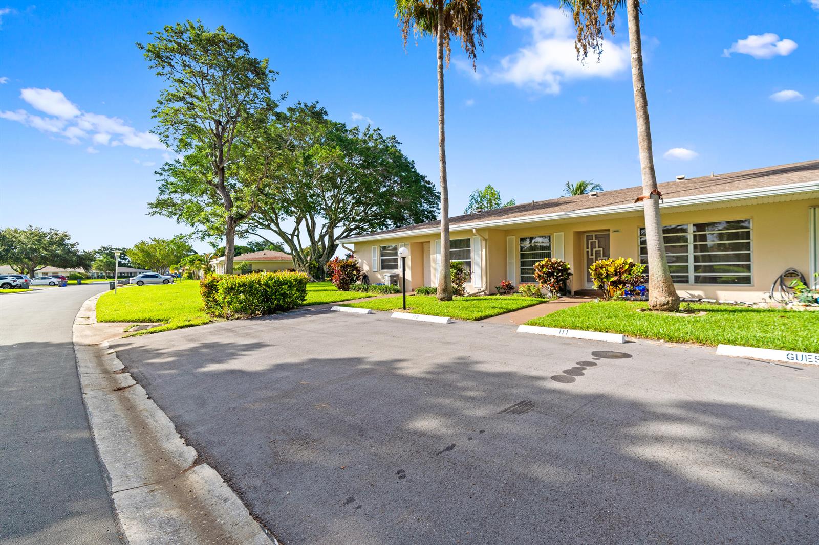 A single-story residential building with a parking area in front and palm trees — 8666 Bella Vista Drive # 111, Boca Raton FL 33433, BOCA RATON, FL