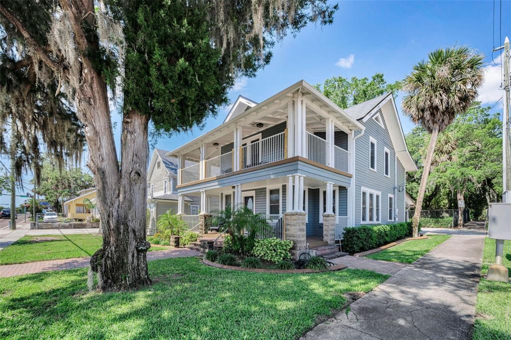 A two-story blue house with a wrap-around porch and a large tree in front — 133 N PINELLAS AVENUE, TARPON SPRINGS, FL