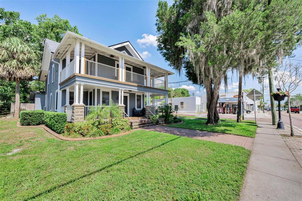 A two-story house with a wrap-around porch and balcony sits on a grassy corner lot — 133 N PINELLAS AVENUE, TARPON SPRINGS, FL