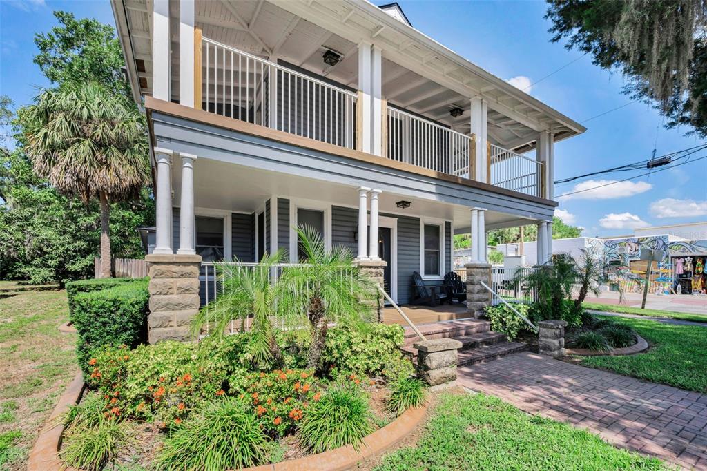 A two-story house with a wrap-around porch, stone pillars, and a brick walkway — 133 N PINELLAS AVENUE, TARPON SPRINGS, FL