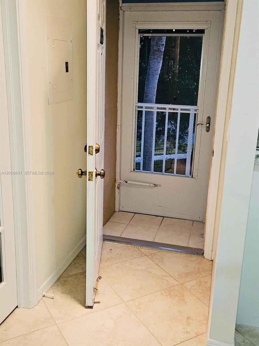 An interior entryway features a white door, a storm door, and light-colored tile flooring — 1335 Mainsail Dr # 1315, Naples FL 34114, NAPLES, FL