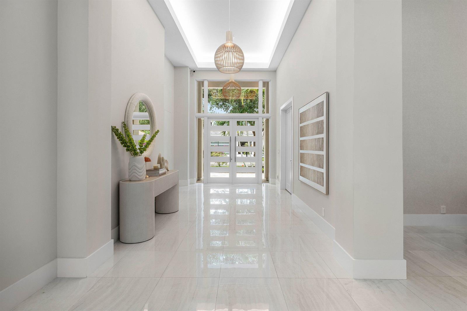 A bright entryway features white tile floors, a modern console table, and a double-door entrance — 3164 Saint Annes Drive, Boca Raton FL 33496, BOCA RATON, FL