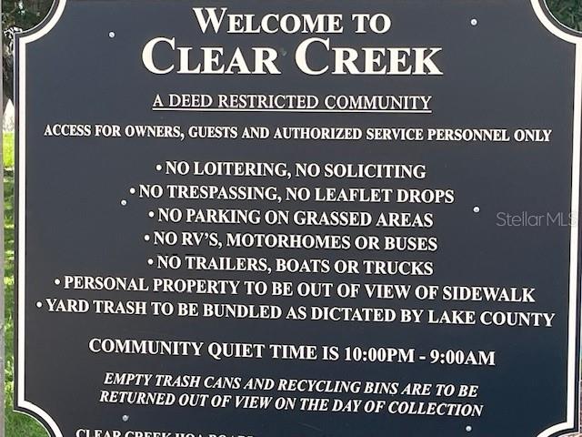 A black sign with white text lists the rules and regulations for the Clear Creek community — 1048 WINDING WATER WAY, CLERMONT, FL