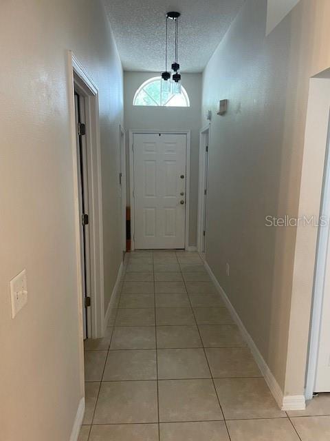 A tiled hallway leads to a white front door with a transom window above — 1048 WINDING WATER WAY, CLERMONT, FL