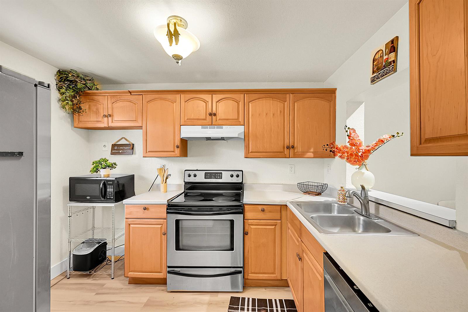A kitchen features wood cabinets, stainless steel appliances, and light-colored countertops — 9503 Boca Cove Circle # 603, Boca Raton FL 33428, BOCA RATON, FL