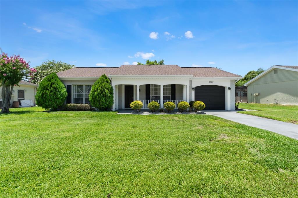 A single-story house with a brown roof, white siding, and a front-facing garage — 8802 SEELEY LANE, HUDSON, FL