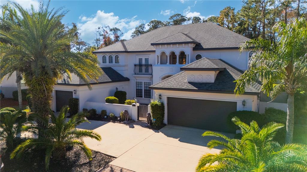 A two-story white stucco house features a multi-car garage and a gated courtyard entrance — 2512 TUSCAN OAKS LANE, JACKSONVILLE, FL