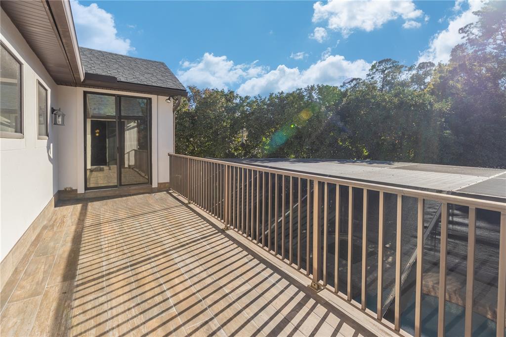 A balcony with wood-look tile flooring and a metal railing overlooks a screened-in area — 2512 TUSCAN OAKS LANE, JACKSONVILLE, FL