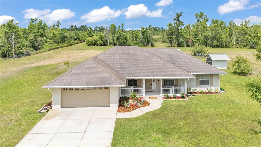 An aerial view of a single-story house with a tan garage and a front porch — 8904 CARROLWOOD DRIVE, LAKELAND, FL