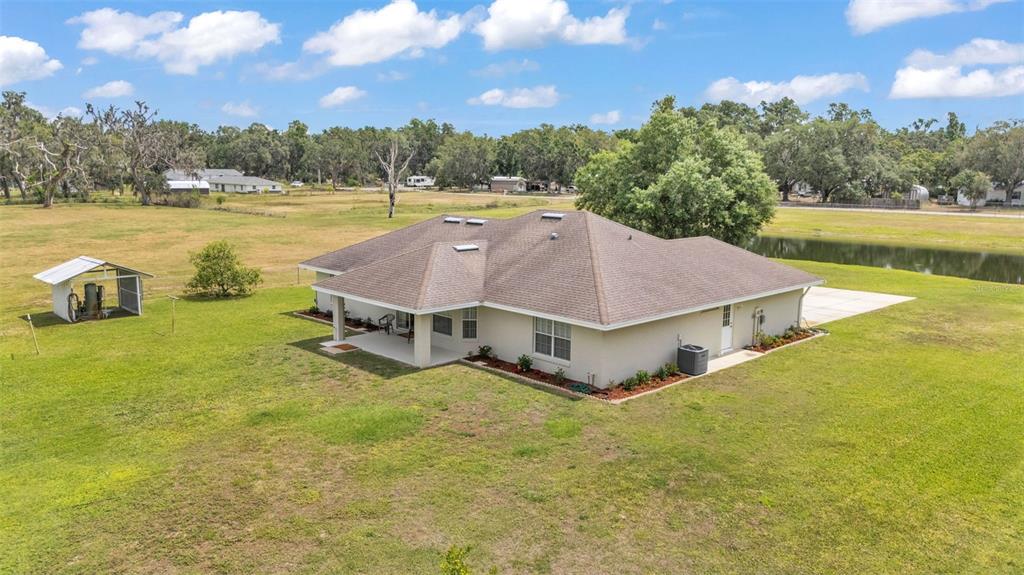 An aerial view of a single-story house with a brown roof and a small shed — 8904 CARROLWOOD DRIVE, LAKELAND, FL
