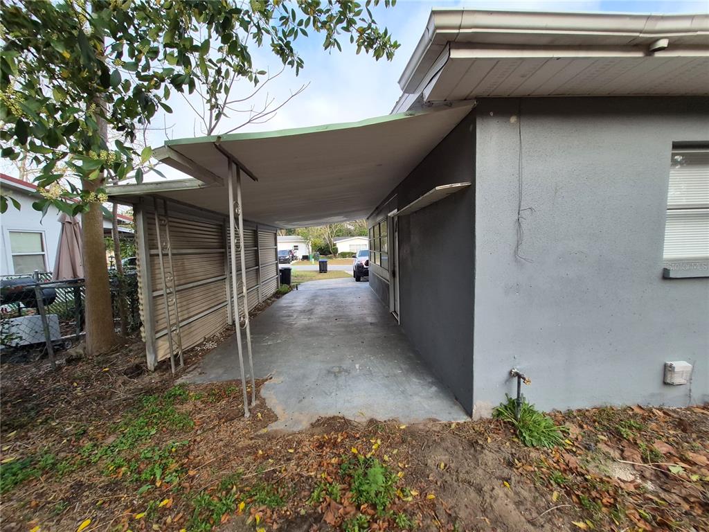 A concrete driveway leads to a covered carport attached to the side of a house — 11 S BARBOUR STREET, BEVERLY HILLS, FL