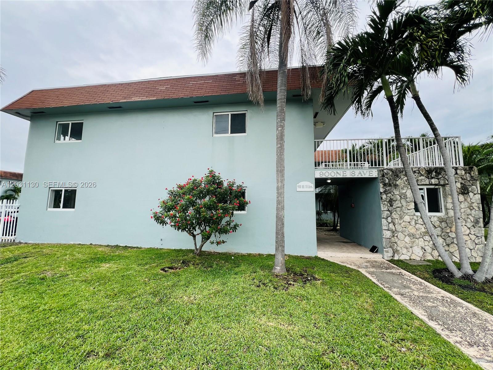 A two-story light blue building features a stone facade, a balcony, and a palm tree — 880 NE 18th Ave # 3, Homestead FL 33033, HOMESTEAD, FL