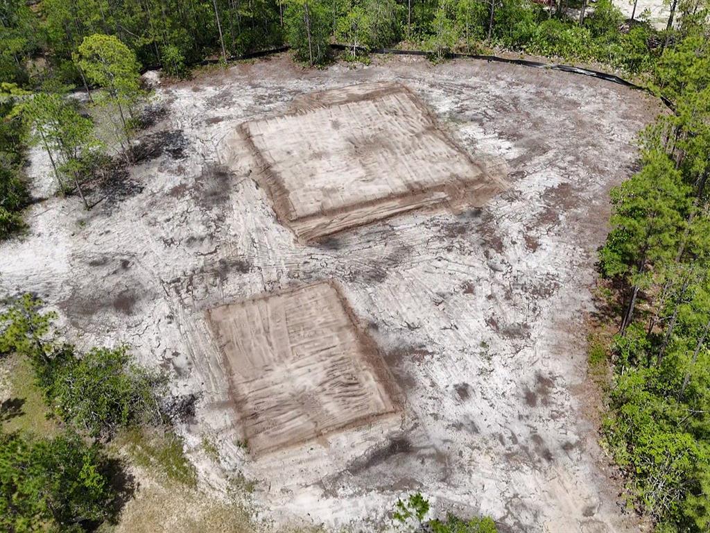 An aerial view shows two cleared, rectangular building pads on a sandy, wooded lot — 4678 GUM ROAD, NEW SMYRNA BEACH, FL
