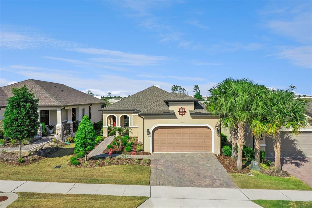An exterior view of a single-story suburban house with a paved driveway and palm trees — 959 BRAEWOOD DRIVE, CLERMONT, FL