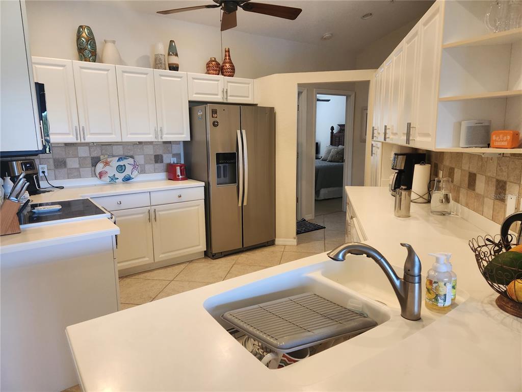 A kitchen with white cabinets, stainless steel appliances, and a white countertop island — 7224 CEDAR HOLLOW CIRCLE, BRADENTON, FL