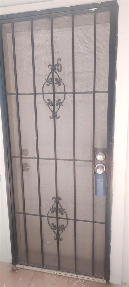 A black metal security screen door is installed over a white entry door — 31 Edmund Road # 5, West Park FL 33023, WEST PARK, FL