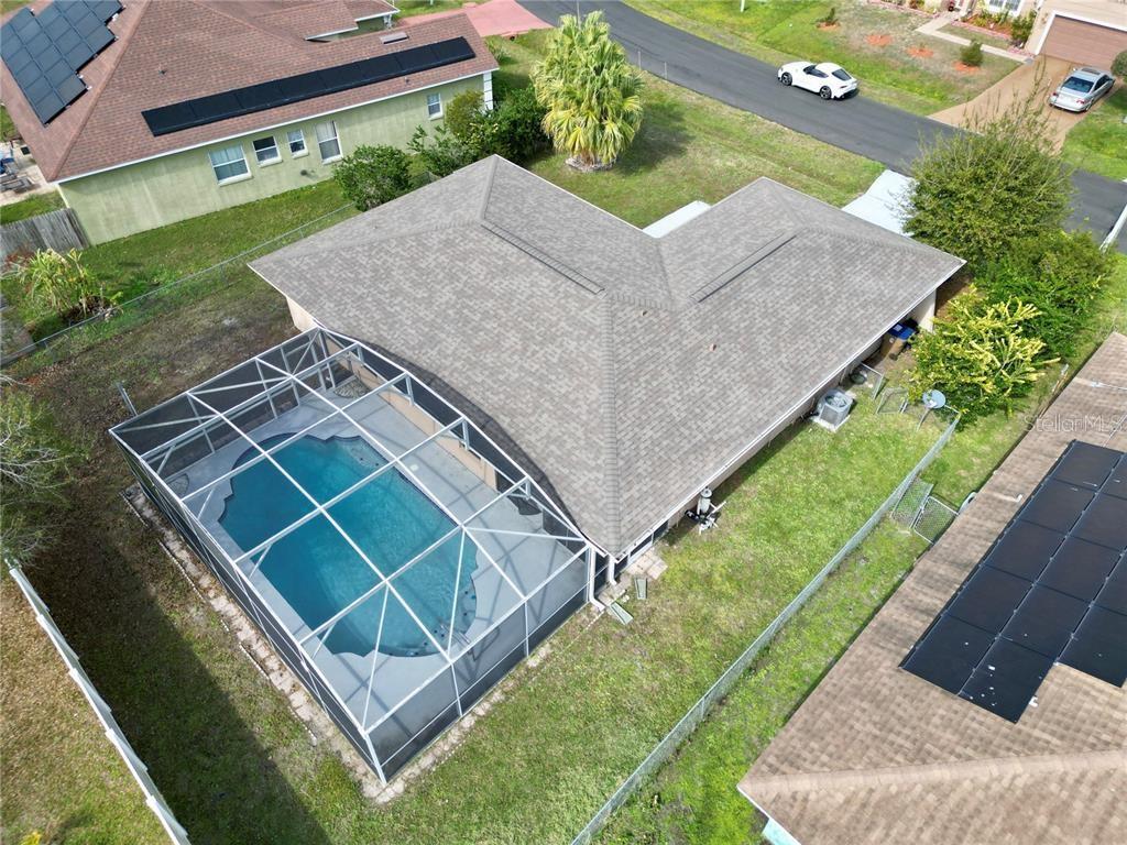 An aerial view shows a house with a screened-in pool and a shingled roof — 620 HERALDO COURT, KISSIMMEE, FL