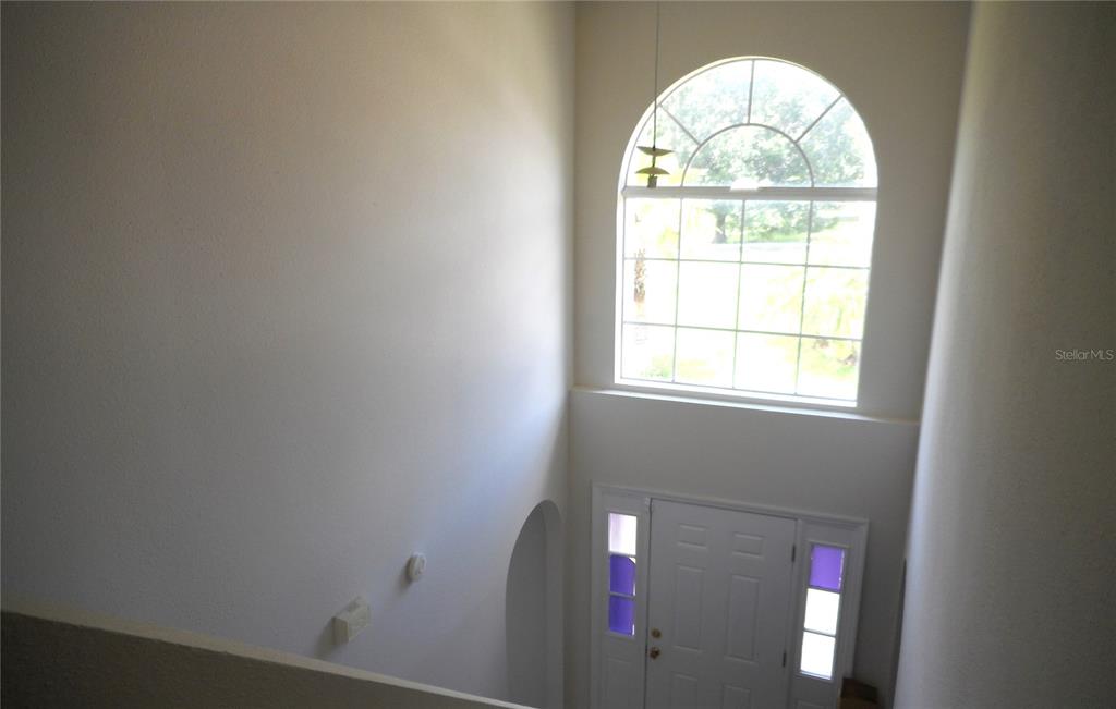 A high-angle view shows an entryway with a tall arched window above a front door — 950 DERBYSHIRE DRIVE, KISSIMMEE, FL