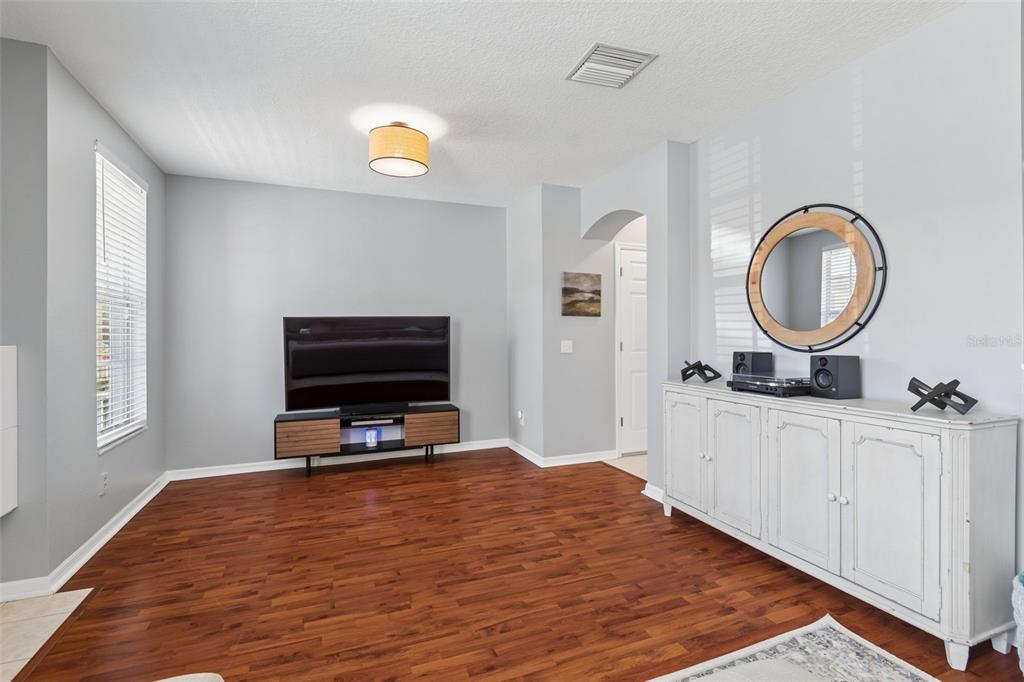 A living room features light gray walls, dark wood flooring, a television console, and a sideboard — 3541 RED ROCK DRIVE, LAND O LAKES, FL