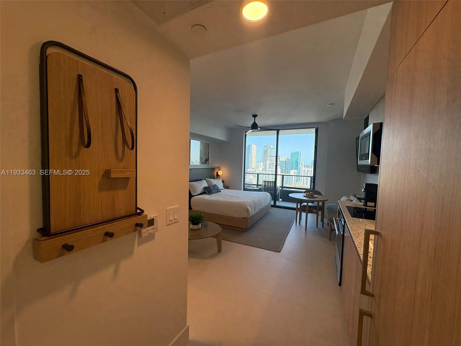 A studio apartment features a kitchen, a bed, a dining area, and a balcony view — 159 NE 6th St # 4010, Miami FL 33132, MIAMI, FL