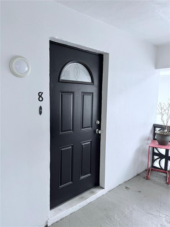 A black front door with a small window and the number eight on a white wall — 11705 3RD STREET E UNIT 8, TREASURE ISLAND, FL