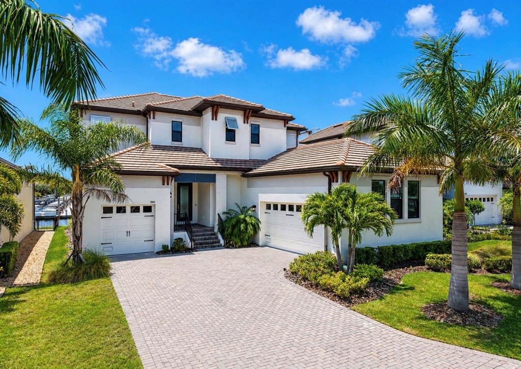 A two-story house with a tiled roof, white stucco exterior, and a paved driveway — 3016 CHRISTOPHERS WATCH LANE, RUSKIN, FL