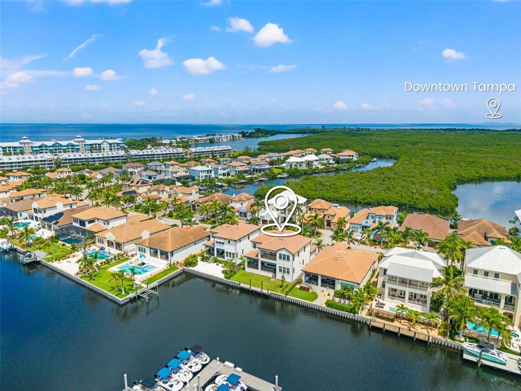 An aerial view shows waterfront houses with pools and boat docks along a canal — 3016 CHRISTOPHERS WATCH LANE, RUSKIN, FL