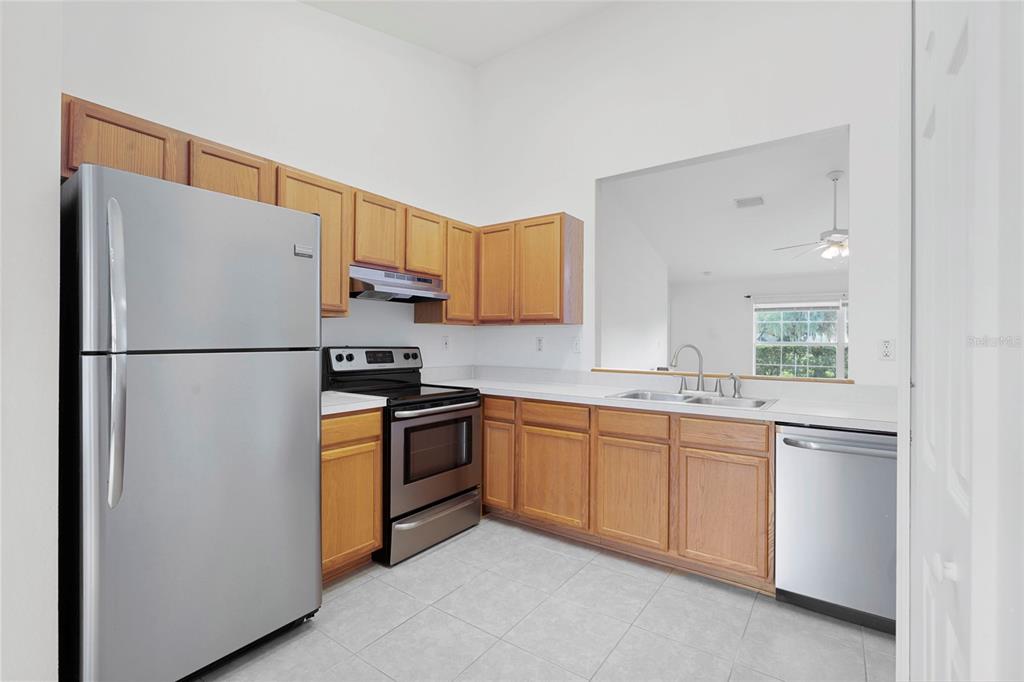 The exterior of a house features a tiled entryway, a dark front door, and green shutters — 6412 LAURELWOOD DRIVE, ZEPHYRHILLS, FL