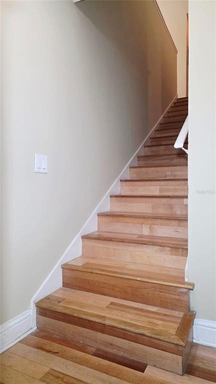 A wooden staircase with light-colored treads leads upward against a plain, light-colored wall — 5416 E MICHIGAN STREET UNIT 6, ORLANDO, FL