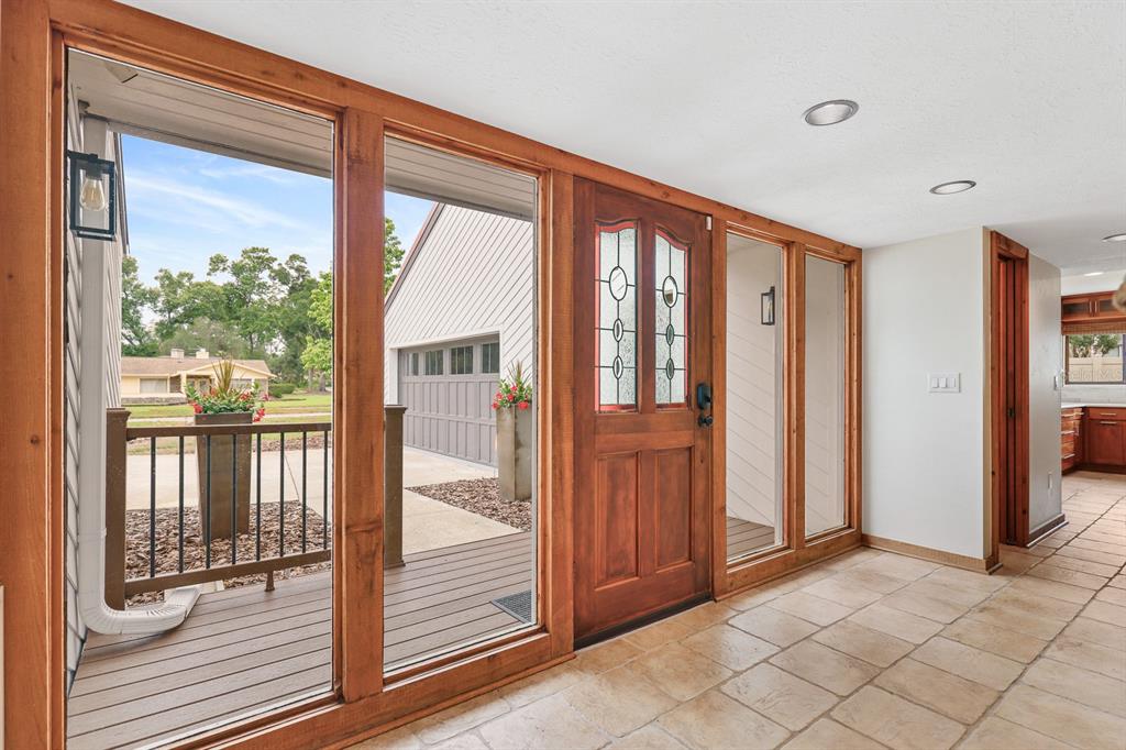 An entryway with tile flooring, a wooden front door, and large windows overlooking a deck — 2925 CHELSEA WOODS DRIVE, VALRICO, FL