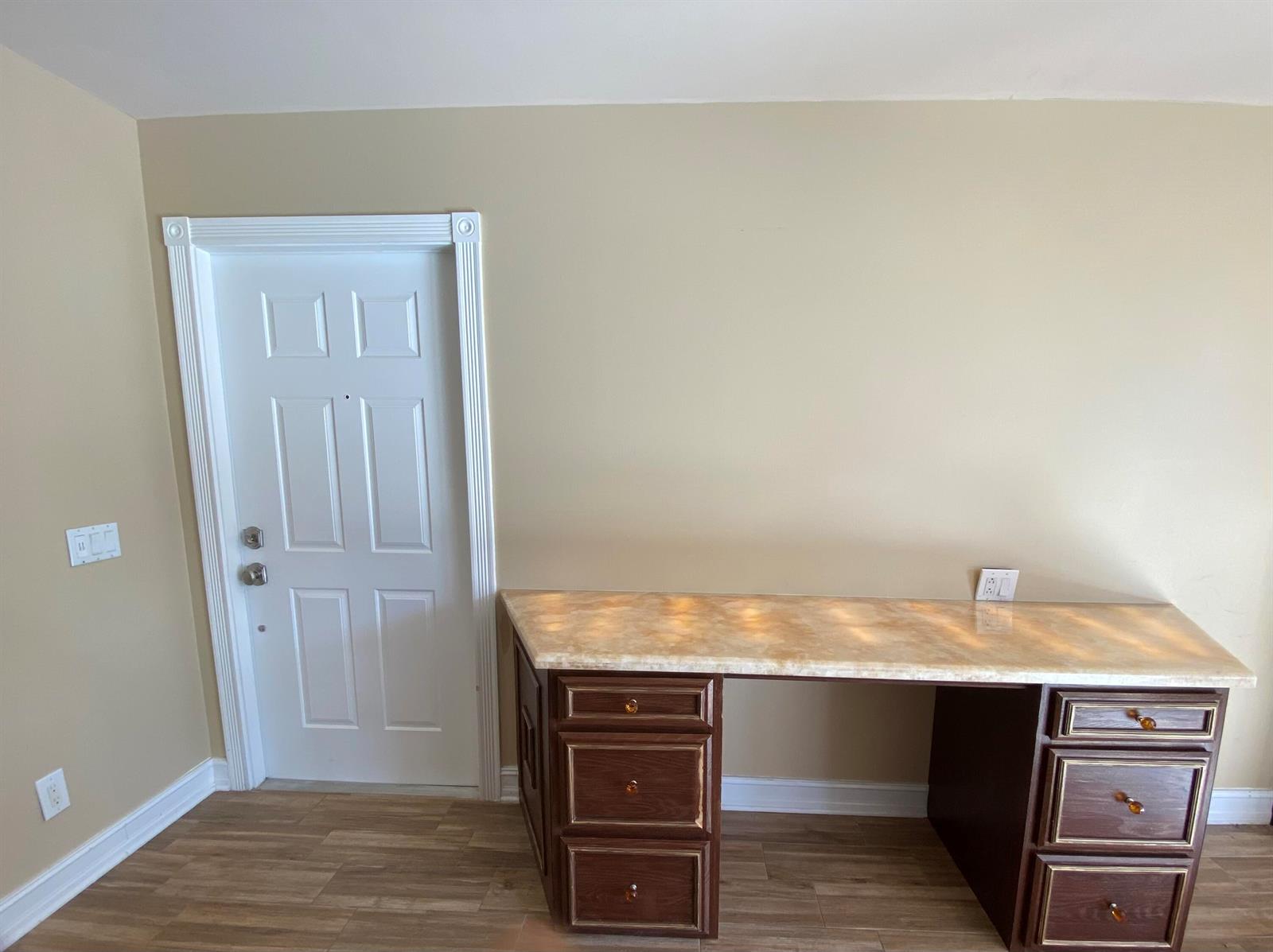 A room features a built-in desk with a stone countertop and dark wood cabinets — 477 Capistrano Drive, Palm Beach Gardens FL 33410, PALM BEACH GARDENS, FL