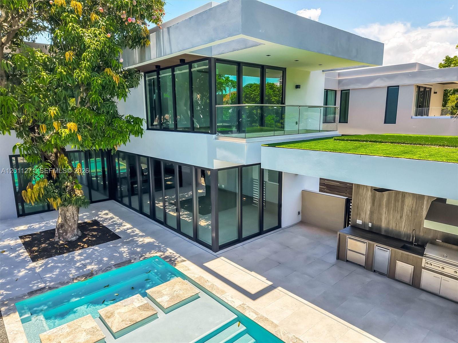 A modern two-story house features a swimming pool, outdoor kitchen, and a large mango tree — 125 SW 29th Rd, Miami FL 33129, MIAMI, FL