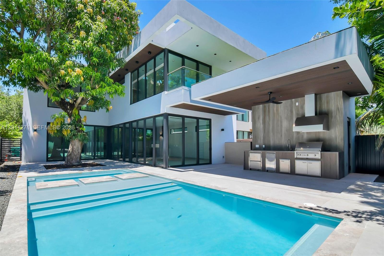 A modern two-story house features a swimming pool, a large tree, and an outdoor kitchen — 125 SW 29th Rd, Miami FL 33129, MIAMI, FL