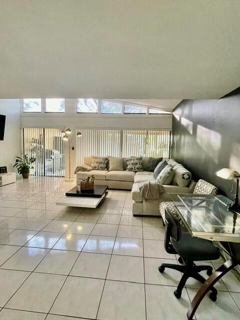 A living room features a large sectional sofa, tile flooring, and a glass-topped desk — 1453 White Pine Drive, Wellington FL 33414, WELLINGTON, FL