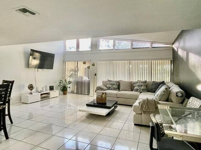 A living room features white tile floors, a large sectional sofa, and vaulted windows — 1453 White Pine Drive, Wellington FL 33414, WELLINGTON, FL