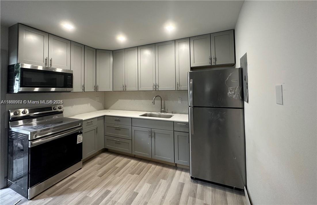 A kitchen features gray cabinets, stainless steel appliances, and light-colored countertops — 1255 NE 110th Ter, Miami FL 33161, MIAMI, FL