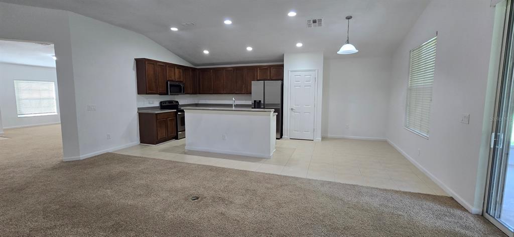 A kitchen with dark wood cabinets, stainless steel appliances, and a white island — 4170 SW 47TH COURT, OCALA, FL
