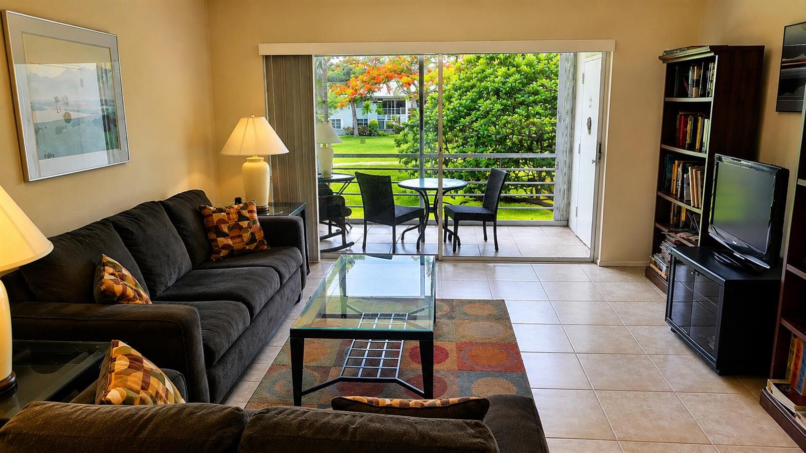 A living room with a dark sofa, glass coffee table, and sliding doors to a balcony — 2620 SW 22nd Avenue # 1004, Delray Beach FL 33445, DELRAY BEACH, FL