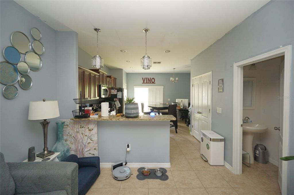 A kitchen with a breakfast bar, pendant lighting, and an adjacent bathroom doorway — 2709 LANTERN HILL AVENUE, BRANDON, FL