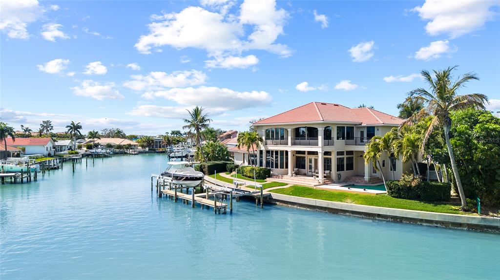 An aerial view shows a waterfront house with a tiled roof, pool, and private boat dock — 4914 59TH AVENUE S, ST PETERSBURG, FL