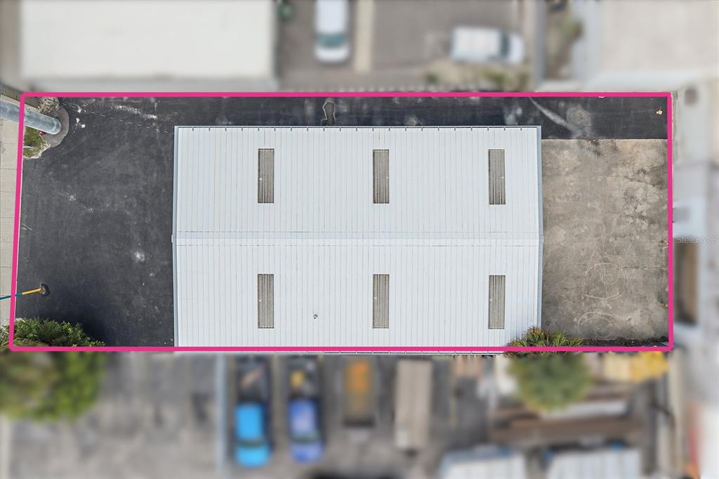 An aerial view shows a rectangular building with a metal roof and six skylights — 2135 12TH STREET, SARASOTA, FL