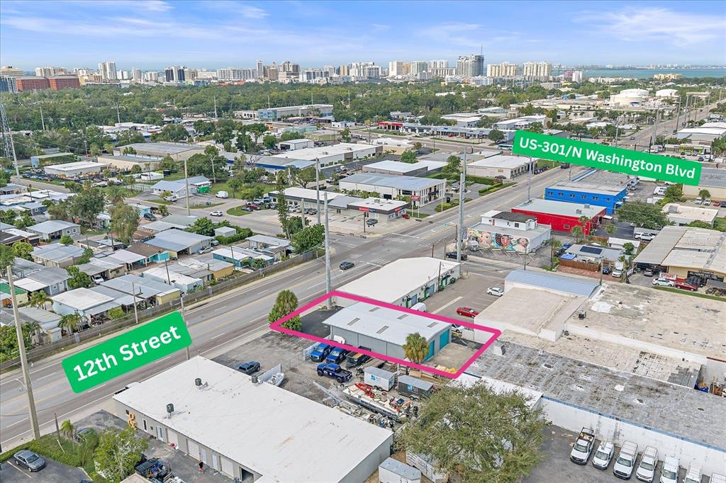 An aerial view shows a small industrial building outlined in pink near a street intersection — 2135 12TH STREET, SARASOTA, FL
