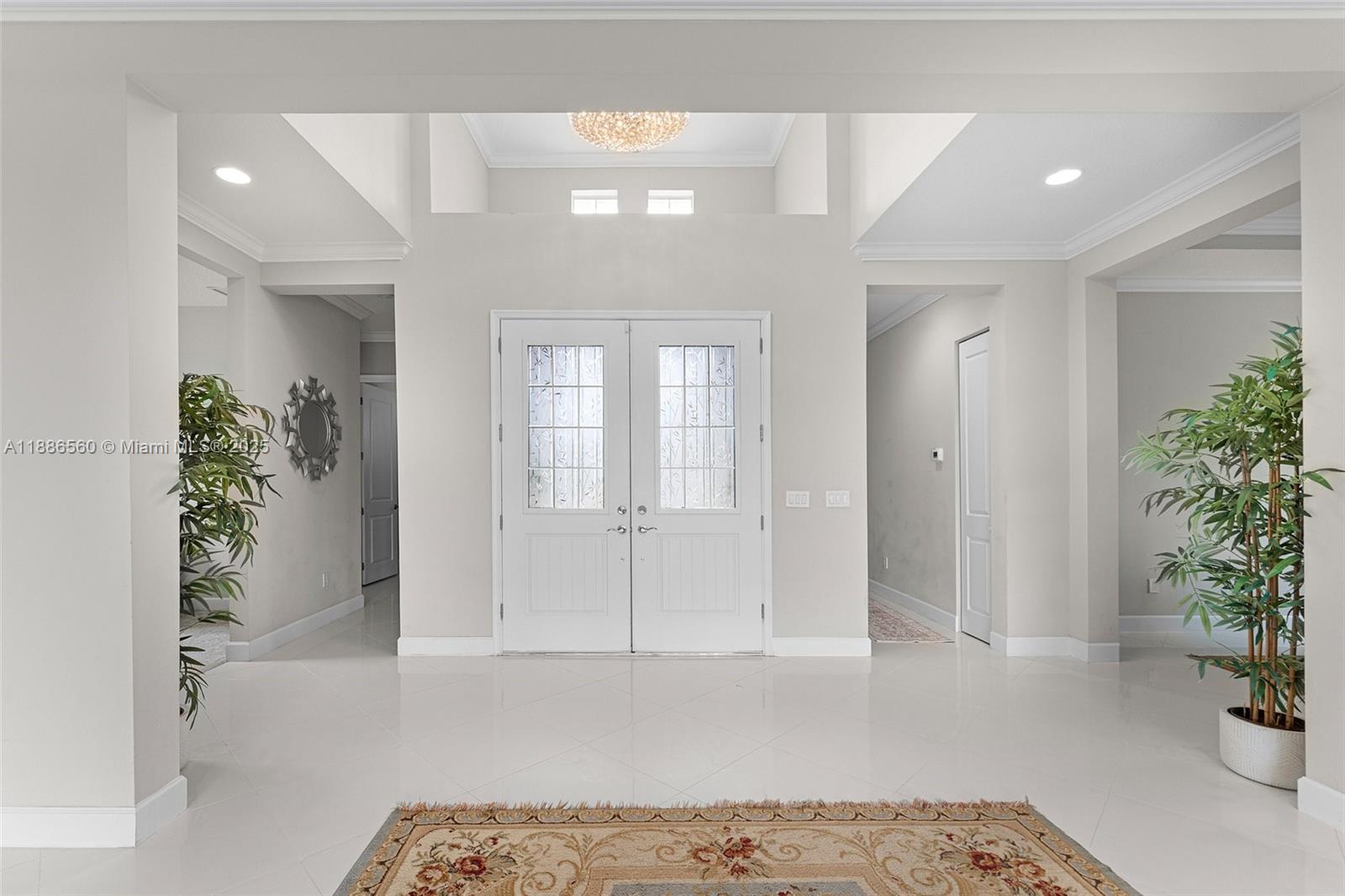 A bright foyer features white tile floors, double entry doors, and a high tray ceiling — 15901 Meadowlark Ct, Loxahatchee FL 33470, LOXAHATCHEE, FL
