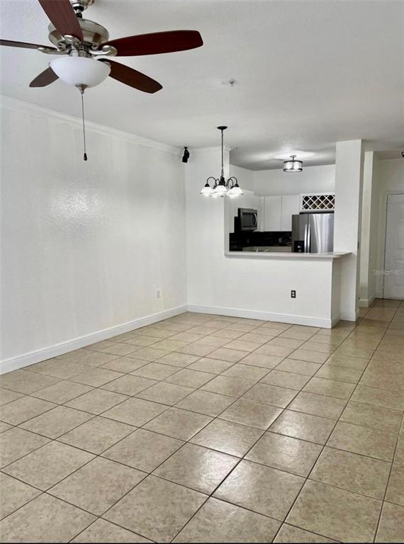 An open living area features a ceiling fan, tiled floors, and a kitchen pass-through window — 2674 ROBERT TRENT JONES DRIVE UNIT 337, ORLANDO, FL