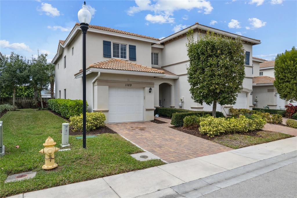 A two-story suburban house with a paved driveway, a garage, and a yellow fire hydrant — 1169 SEPIA LANE, LAKE WORTH, FL