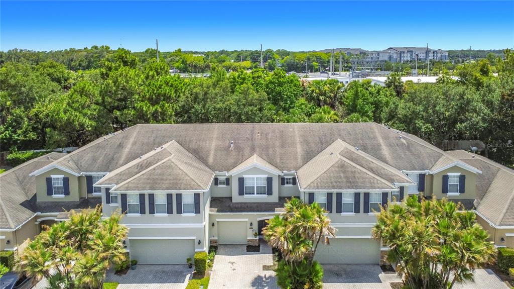 An aerial view of a multi-unit townhouse complex with beige siding and gray shingled roofs — 2547 RIVER LANDING DRIVE, SANFORD, FL