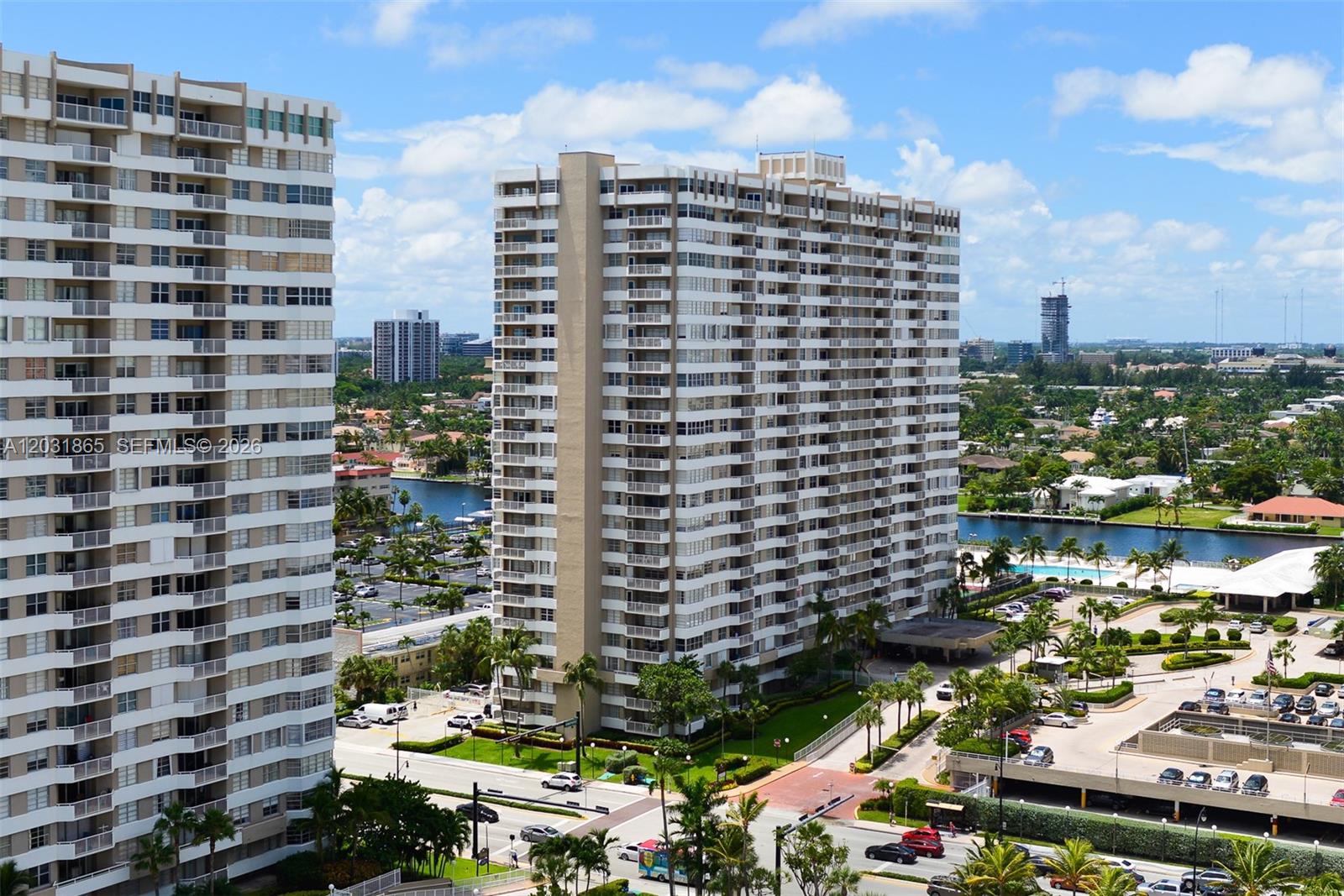 Two tall residential apartment buildings stand over a parking lot and a canal — 1985 S Ocean Dr # 4G, Hallandale Beach FL 33009, HALLANDALE BEACH, FL