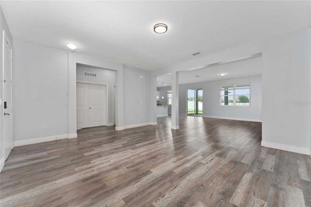 An open-concept living area features light gray walls, wood-look flooring, and recessed lighting — 12845 SAWGRASS PINE CIRCLE, ORLANDO, FL