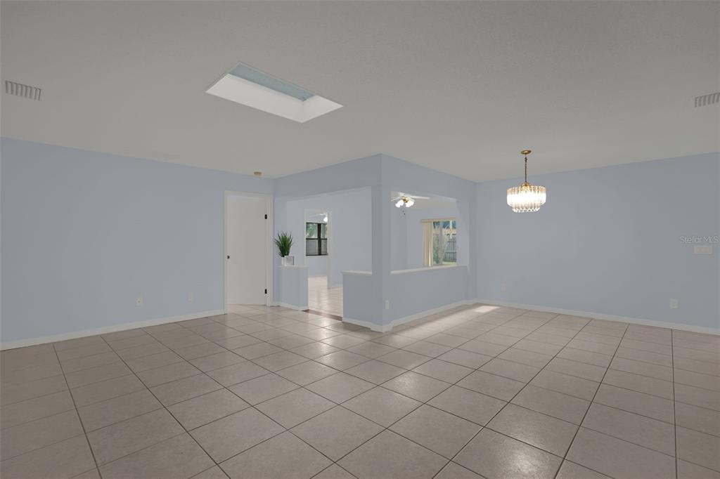 An open-concept living area features light blue walls, tiled floors, a skylight, and a chandelier — 2807 SUNBRANCH DRIVE, ORLANDO, FL