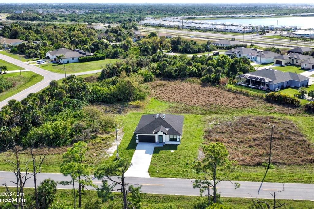 An aerial view shows a single-story house with a driveway situated on a large lot — 336 SUNSET ROAD, ROTONDA WEST, FL